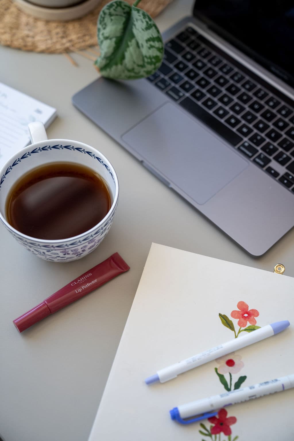 Tasse de thé, carnet et ordinateur sur un bureau